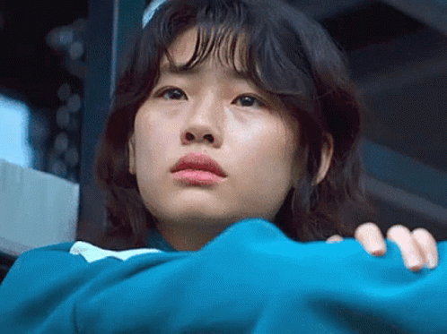 A Close Up Of A Woman 'S Face With A Blue Jacket On . GIF