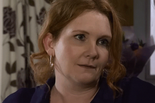 A Close Up Of A Woman 'S Face With A Blue Shirt On GIF