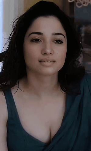 A Close Up Of A Woman 'S Face With A Blue Top On GIF