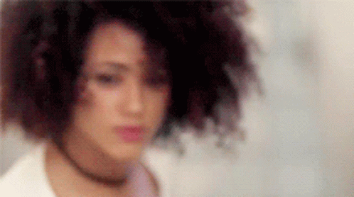 A Close Up Of A Woman 'S Face With A Blurred Background And A Choker . GIF