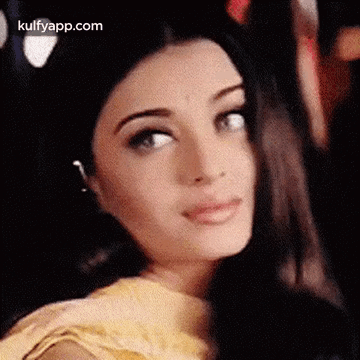 A Close Up Of A Woman 'S Face With A Blurred Background Looking At The Camera . GIF