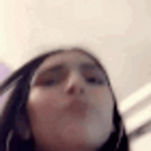 A Close Up Of A Woman 'S Face With A Blurred Background . GIF