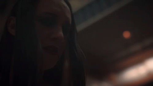 A Close Up Of A Woman 'S Face With A Blurry Background GIF