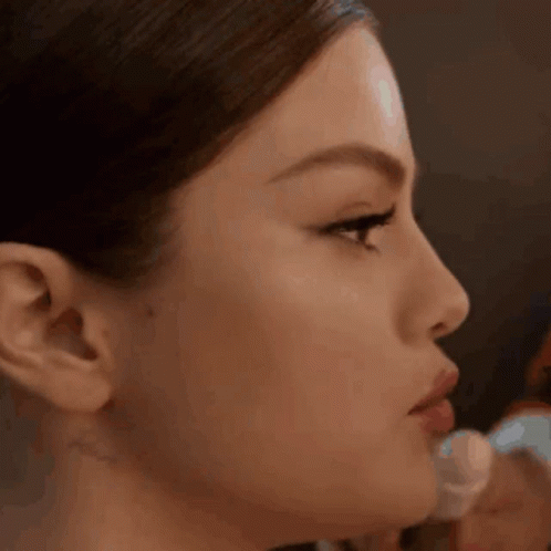 A Close Up Of A Woman 'S Face With A Brush On Her Lips . GIF