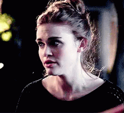 A Close Up Of A Woman 'S Face With A Bun In Her Hair . GIF