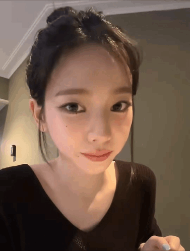 A Close Up Of A Woman 'S Face With A Bun GIF