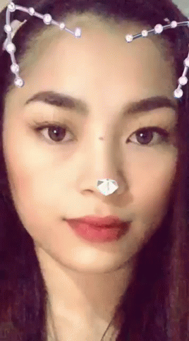 A Close Up Of A Woman 'S Face With A Cat Ear Headband . GIF
