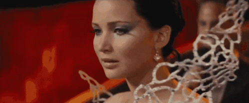 A Close Up Of A Woman 'S Face With A Chain Around Her Neck . GIF