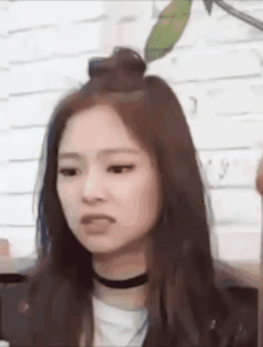 A Close Up Of A Woman 'S Face With A Choker Around Her Neck . GIF