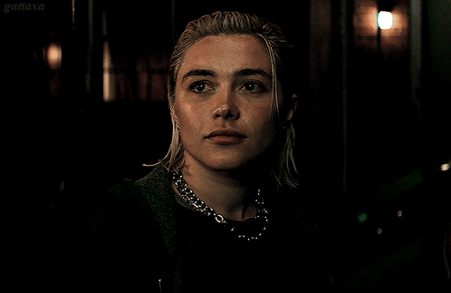A Close Up Of A Woman 'S Face With A Dark Background And The Word Gatiaxa On The Bottom Right GIF