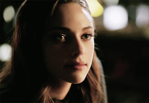 A Close Up Of A Woman 'S Face With A Dark Background GIF