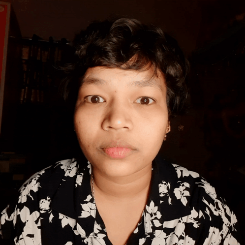 A Close Up Of A Woman 'S Face With A Floral Shirt GIF