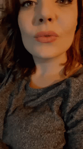 A Close Up Of A Woman 'S Face With A Gray Shirt GIF