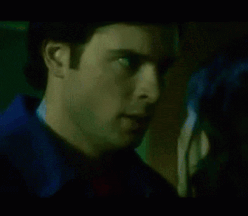 A Close Up Of A Woman 'S Face With A Green And Blue Light Behind Her GIF