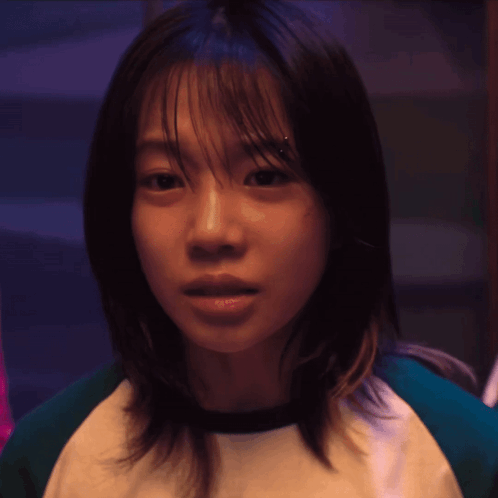 A Close Up Of A Woman 'S Face With A Green And White Shirt On GIF