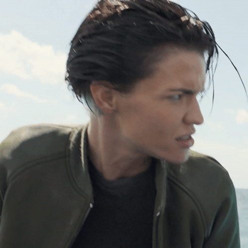 A Close Up Of A Woman 'S Face With A Green Jacket GIF