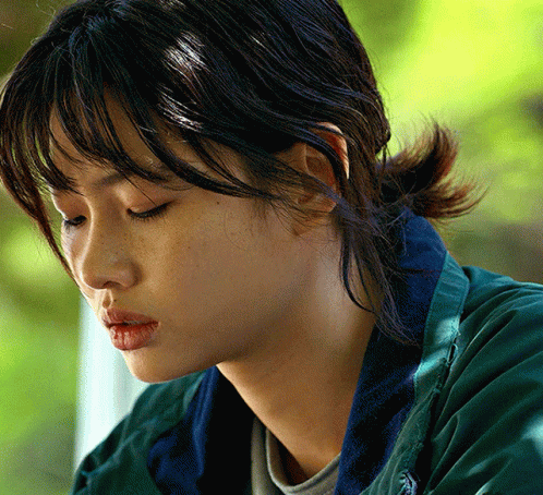 A Close Up Of A Woman 'S Face With A Green Jacket GIF
