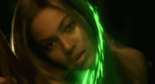 A Close Up Of A Woman 'S Face With A Green Light Shining On It . GIF