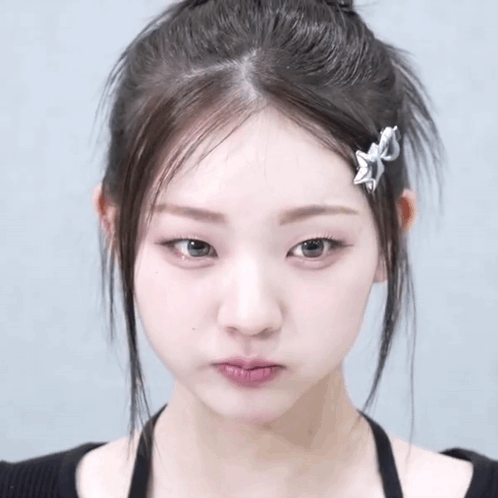 A Close Up Of A Woman 'S Face With A Hair Clip On Her Hair GIF