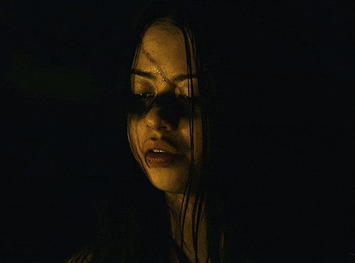 a close up of a woman 's face with a hand covering her mouth