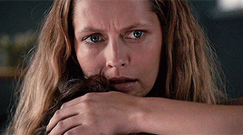 A Close Up Of A Woman 'S Face With A Hand On Her Face GIF
