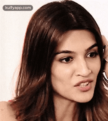 A Close Up Of A Woman 'S Face With A Hand On Her Head . GIF