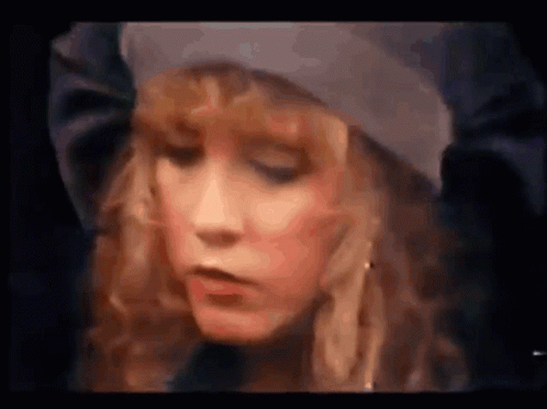 A Close Up Of A Woman 'S Face With A Hat On . GIF