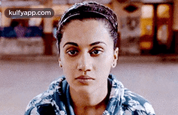 A Close Up Of A Woman 'S Face With A Headband Around Her Head . GIF