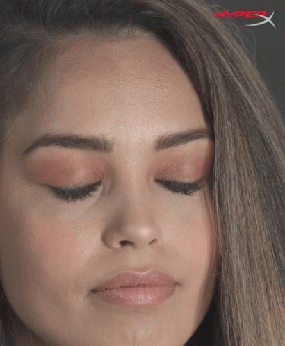 A Close Up Of A Woman 'S Face With A Hyperx Logo In The Corner GIF