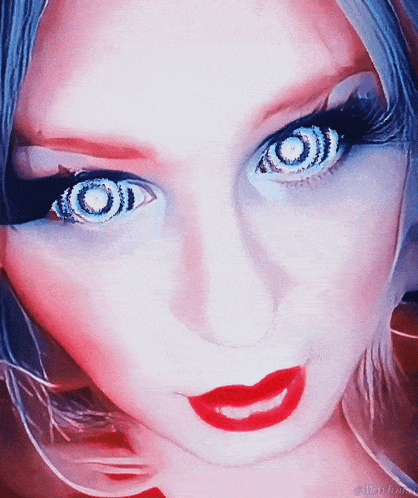 A Close Up Of A Woman 'S Face With A Hypnotic Look On Her Eyes GIF