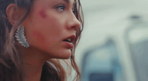 A Close Up Of A Woman 'S Face With A Leaf Earring GIF