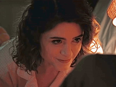 A Close Up Of A Woman 'S Face With A Light Shining On Her Face . GIF