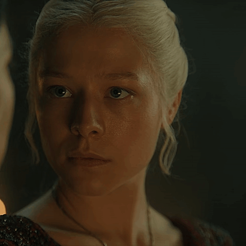 A Close Up Of A Woman 'S Face With A Man In The Background GIF