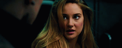 A Close Up Of A Woman 'S Face With A Man In The Background . GIF