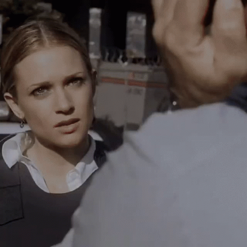 A Close Up Of A Woman 'S Face With A Man 'S Hand Behind Her GIF