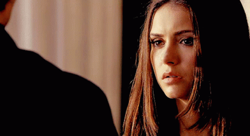 A Close Up Of A Woman 'S Face With A Man Standing In The Background GIF