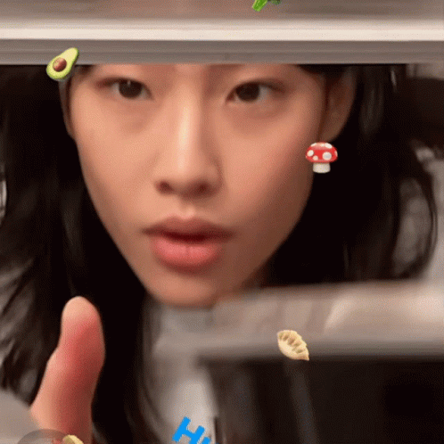 A Close Up Of A Woman 'S Face With A Mushroom And An Avocado On Her Head GIF