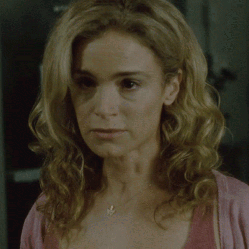A Close Up Of A Woman 'S Face With A Necklace GIF