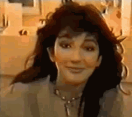 A Close Up Of A Woman 'S Face With A Necklace Around Her Neck . GIF