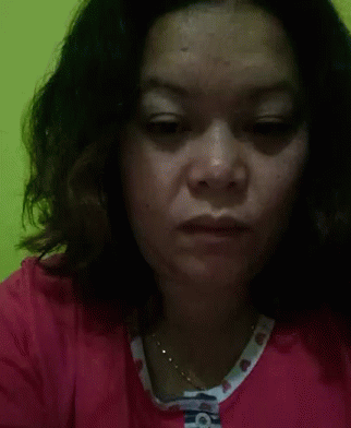 A Close Up Of A Woman 'S Face With A Necklace Around Her Neck . GIF