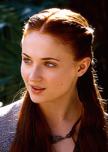 A Close Up Of A Woman 'S Face With A Necklace Around Her Neck GIF