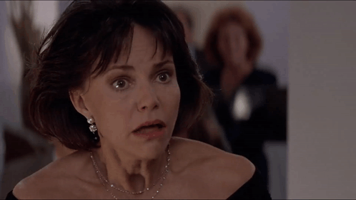 A Close Up Of A Woman 'S Face With A Necklace On GIF
