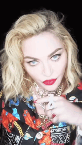 A Close Up Of A Woman 'S Face With A Necklace That Says Macau On It GIF