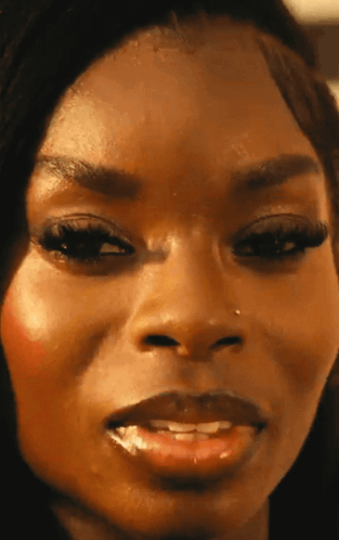 A Close Up Of A Woman 'S Face With A Nose Piercing GIF