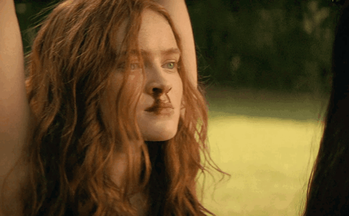 A Close Up Of A Woman 'S Face With A Nose Ring GIF
