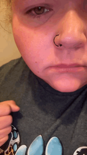 A Close Up Of A Woman 'S Face With A Nose Ring On It GIF