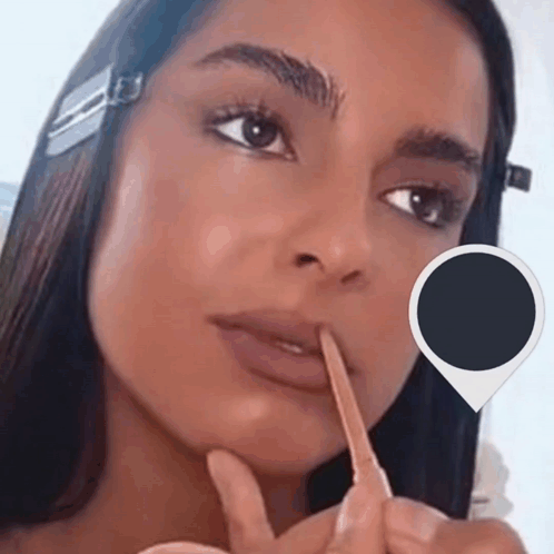 A Close Up Of A Woman 'S Face With A Pencil In Her Mouth GIF
