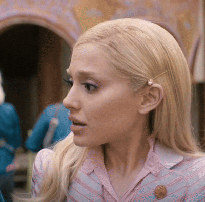A Close Up Of A Woman 'S Face With A Penny Pin In Her Hair GIF