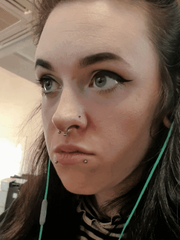 A Close Up Of A Woman 'S Face With A Piercing In Her Nose GIF