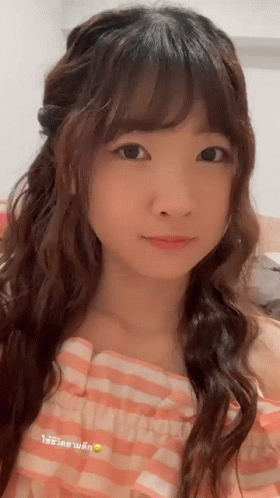 A Close Up Of A Woman 'S Face With A Pink And White Checkered Shirt GIF